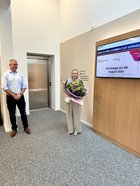 Geschäftsführer bedankt sich bei der Künstlerin mit einem Blumenstrauß