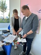 Leiterin der Drobs Goslar und Lars Fischer sehen die Kollage an