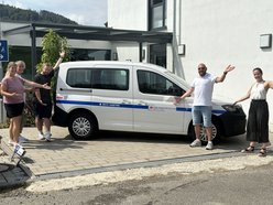 Mitarbeitende stehen am neuen Auto