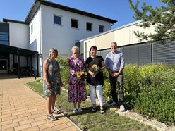 Blumen werden von Geschäftsführung an Pflegedienstleitung überreicht